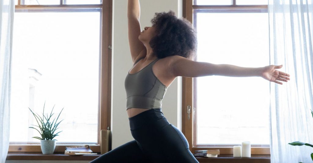 Frau beim Yoga in hellem Wohnraum